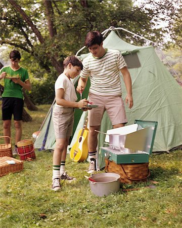 simsearch:862-03808818,k - 1960s THREE BOYS AT CAMPSITE COOKING CAMP STOVE EATING FOOD TENT TEENS Foto de stock - Direito Controlado, Número: 846-05646763