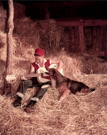 simsearch:846-09012877,k - 1950s BOY PLAYING GUITAR COLLIE DOG SITTING HAY BALES INSIDE BARN Stock Photo - Rights-Managed, Code: 846-05646827