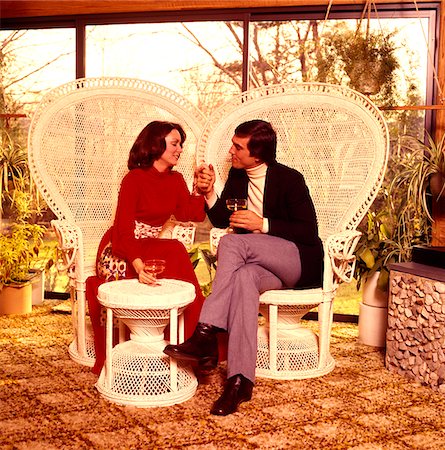 simsearch:846-03166237,k - 1970s MAN WOMAN COUPLE HOLDING HANDS DRINKING WINE ON PATIO SITTING WHITE WICKER RATTAN CHAIRS TROPICAL MOTIF Stock Photo - Rights-Managed, Code: 846-05646843