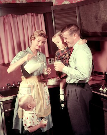 50ER JAHRE-FAMILIE IN DER KÜCHE MUTTER GIEßT MILCH AUS KRUG FÜR VATER UND KINDER Stockbilder - Lizenzpflichtiges, Bildnummer: 846-05646867