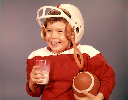 football (sport) - 1960ER JAHRE BOY TRINKEN MILCH TRAGEN FOOTBALL HELM ROT JERSEY BALL HALTEN Stockbilder - Lizenzpflichtiges, Bildnummer: 846-05646891