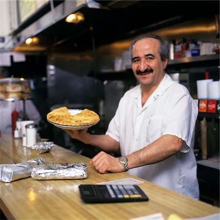 small business - PORTRAIT SOURIANT HOMME TRAVAIL DERRIÈRE COUNTER IN HOLDING DINER PIE Photographie de stock - Rights-Managed, Code: 846-05646905