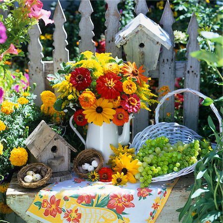 flowers vintage - BOUQUET OF YELLOW AND RED FLOWERS IN PITCHER BIRD NESTS & HOUSES BASKET OF GRAPES IN GARDEN Stock Photo - Rights-Managed, Code: 846-05646907