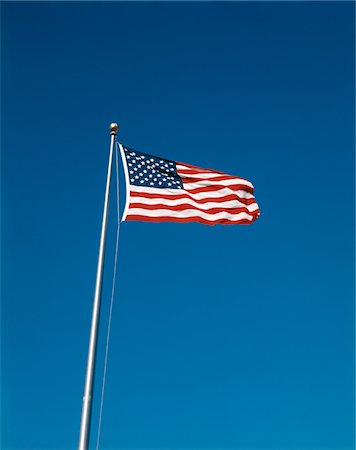 simsearch:846-02794370,k - U.S. FLAG FLYING ON FLAGPOLE BLUE CLOUDLESS SKY Stock Photo - Rights-Managed, Code: 846-05647030