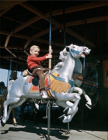 roundabout - 1950s EXCITED BOY RIDING CARVED WOODEN CAROUSEL MERRY-GO-ROUND HORSE Stock Photo - Rights-Managed, Code: 846-05647136