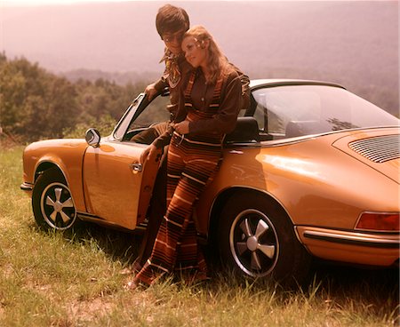 ANNÉES 1970 ÉLÉGAMMENT HABILLÉS COUPLE DEBOUT ENSEMBLE LEANING ON A PORSCHE CONVERTIBLE AUTOMOBILE VOITURE DE SPORT Photographie de stock - Rights-Managed, Code: 846-05647207