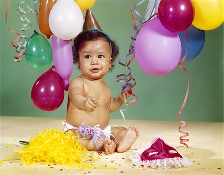 party indoors retro - 1960s AFRICAN-AMERICAN BABY BOY WEARING PARTY HAT WITH BALLOONS STREAMERS AROUND Foto de stock - Con derechos protegidos, Código: 846-05647264