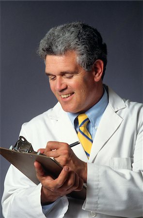 SMILING  MAN DOCTOR WRITING ON CLIPBOARD CHART Stock Photo - Rights-Managed, Code: 846-05647262
