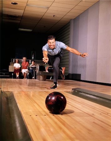 fun bowling alley - 1960s SMILING MAN IN GOOD FORM RELEASING BOWLING BALL DOWN LANE WIFE WOMAN 2 KIDS BEHIND HIM Stock Photo - Rights-Managed, Code: 846-05647421