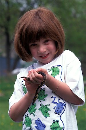 1990s 4-YEAR-OLD GIRL LOOKING AT CAMERA HOLDING JUVENILE BALL PYTHON Python regius SNAKE Stock Photo - Rights-Managed, Code: 846-05647622