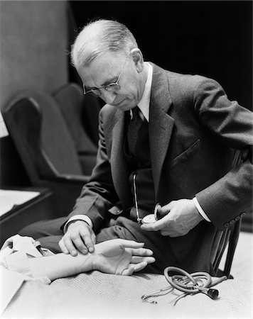 simsearch:846-06112172,k - 1930s DOCTOR AT BEDSIDE TAKING PATIENT'S PULSE TIMING WITH POCKET WATCH Stock Photo - Rights-Managed, Code: 846-05647685