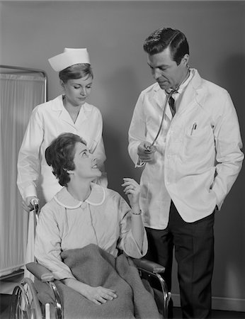 simsearch:846-02794863,k - 1960s MAN DOCTOR WOMAN NURSE TALKING TO SMILING FEMALE PATIENT SITTING IN HOSPITAL WHEELCHAIR Foto de stock - Con derechos protegidos, Código: 846-05647694