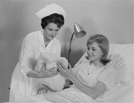simsearch:846-02794819,k - 1960s WOMAN NURSE GIVING BABY TO SMILING MOTHER PATIENT SITTING IN HOSPITAL BED Stock Photo - Rights-Managed, Code: 846-05647693