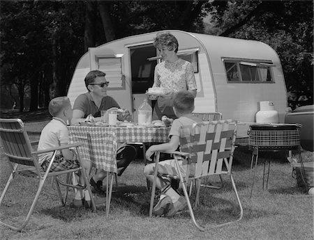 1960s FAMILY CAMPING EATING MEAL BESIDE RV CAMPER Foto de stock - Con derechos protegidos, Código: 846-05647701