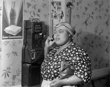 simsearch:846-02797676,k - ANNÉES 1930 - ANNÉES 1940 AFRO-AMÉRICAIN FEMME PARLAIT AU PUBLIC PAYE MUR TÉLÉPHONE IN PUBLIC RESTAURANT Photographie de stock - Rights-Managed, Code: 846-05647724