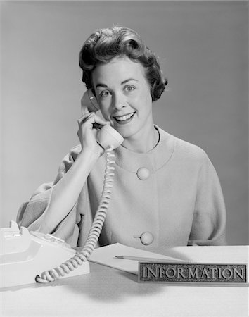 simsearch:846-02795997,k - 1960s SMILING WOMAN SECRETARY TALKING ON TELEPHONE INFORMATION DESK Stock Photo - Rights-Managed, Code: 846-05647736