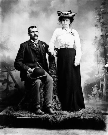 photography 1900 portrait black white - 1890s - 1900 TURN OF THE CENTURY PORTRAIT SERIOUS COUPLE HOLDING HANDS TOGETHER IN RUSTIC STUDIO SETTING Stock Photo - Rights-Managed, Code: 846-05647780