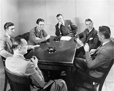 simsearch:846-02797198,k - 1930s - 1940s 6 BUSINESSMEN MEETING IN BOARDROOM AROUND TABLE WITH ASHTRAYS Stock Photo - Rights-Managed, Code: 846-05647797