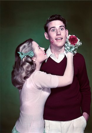 romantic boy hug images - ANNÉES 1940 - ANNÉES 1950 TEEN COUPLE GIRL HOLDING BOUQUET BOUQUET ÉTREINDRE SURPRIS GARÇON ROUGE À LÈVRES KISS ON JOUE Photographie de stock - Rights-Managed, Code: 846-05647818