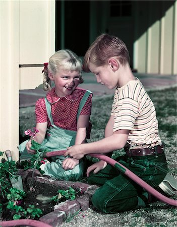 1950s BOY GIRL BROTHER SISTER PLANTING FLOWERS IN GARDEN Foto de stock - Con derechos protegidos, Código: 846-05647832