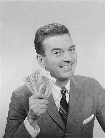 simsearch:846-02796076,k - 1950s - 1960s SMILING MAN HOLDING A FISTFUL OF MONEY FAKE BILLS Stock Photo - Rights-Managed, Code: 846-05647914