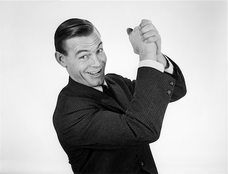 simsearch:846-05646034,k - 1950s - 1960s SMILING BUSINESSMAN HANDS CLASPED OVERHEAD IN SUCCESSFUL WINNER SYMBOLIC SIGN Stock Photo - Rights-Managed, Code: 846-05647927