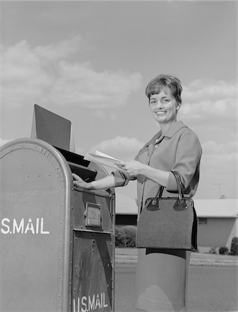 simsearch:846-05648259,k - ANNÉES 1960 SOURIANT LETTRES CHUTE FEMME IN POSTAL BOÎTE AUX LETTRES Photographie de stock - Rights-Managed, Code: 846-05647933