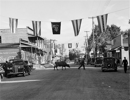 retro scene - 1930s MAIN STREET SMALL TOWN WITH FLAGS FLYING & COW CROSSING STREET Stock Photo - Rights-Managed, Code: 846-05647972