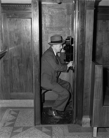 simsearch:846-03163297,k - 1940s MAN SITTING IN WOODEN TELEPHONE BOOTH SPEAKING INTO RECEIVER Stock Photo - Rights-Managed, Code: 846-05647973