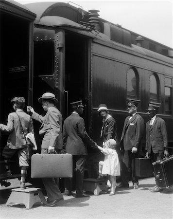 simsearch:846-05647706,k - 1920s FAMILY MOTHER FATHER SON DAUGHTER BOARDING PASSENGER TRAIN ASSISTED BY TRAINMAN AND PORTERS CARRYING LUGGAGE OUTDOOR Foto de stock - Con derechos protegidos, Código: 846-05648054