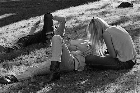 ANNÉES 1960 - ANNÉES 1970 HIPPIE COUPLE FEMME AVEC LONGUE BLONDE CHEVEUX S'ASSEOIR À CÔTÉ DE L'HOMME COUCHÉ DANS L'HERBE Photographie de stock - Rights-Managed, Code: 846-05648065