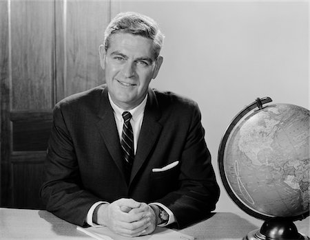 portrait businessman black and white - 1960s SMILING MAN SITTING AT DESK WITH EARTH GLOBE Stock Photo - Rights-Managed, Code: 846-05648123