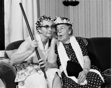 1950s - 1960s TWO ELDERLY WOMEN CHARACTERS GOSSIPING ONE WOMAN WITH HAIR CURLERS OTHER WITH HAT Foto de stock - Con derechos protegidos, Código: 846-05648207
