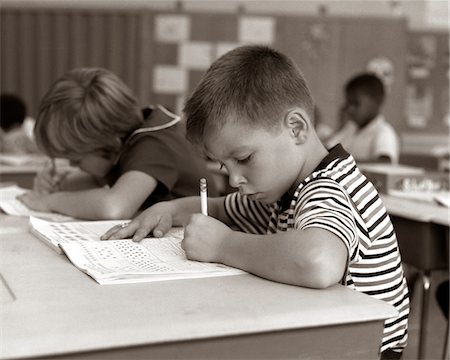 simsearch:846-02793574,k - 1960s BOY STRIPED T-SHIRT ELEMENTARY SCHOOL CLASSROOM SITTING DESK WRITING TEST Stock Photo - Rights-Managed, Code: 846-05648232