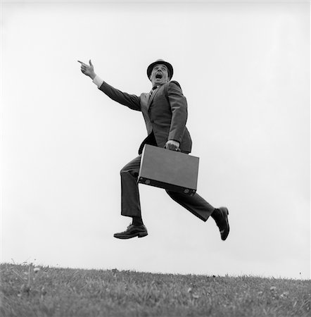 1960s BUSINESSMAN CARRYING A BRIEFCASE RUNNING YELLING AND JUMPING IN THE AIR OUTDOOR POINTING FINGER FORWARD Stock Photo - Rights-Managed, Code: 846-05648249