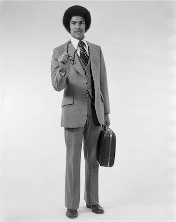 simsearch:846-02795960,k - 1970s AFRICAN AMERICAN BUSINESS MAN THREE PIECE SUIT BRIEFCASE POINTING WITH EYEGLASSES Stock Photo - Rights-Managed, Code: 846-05648288