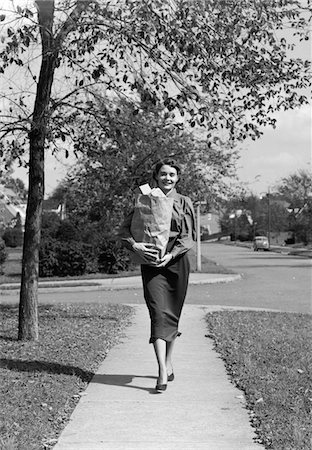 1950s WOMAN WALKING ON SIDEWALK CARRYING A GROCERY BAG FULL OF FOOD Stock Photo - Rights-Managed, Code: 846-05648318