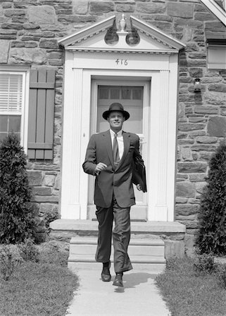 1950s MAN SMILING BUSINESSMAN PROUD LOOK OF SATISFACTION WALKING OUT SUBURBAN HOUSE FRONT DOOR WEARING HAT CARRYING BRIEFCASE Stock Photo - Rights-Managed, Code: 846-05648356