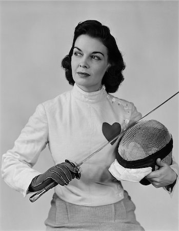 simsearch:846-02792348,k - 1940s PORTRAIT BRUNETTE WOMAN WITH FENCING GEAR HELMET EPEE VEST WITH HEART Stock Photo - Rights-Managed, Code: 846-05648371