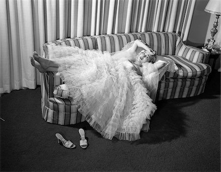 1950s WOMAN IN CHIFFON EVENING GOWN SHOES OFF LYING ON STRIPED COUCH Stock Photo - Rights-Managed, Code: 846-05648394