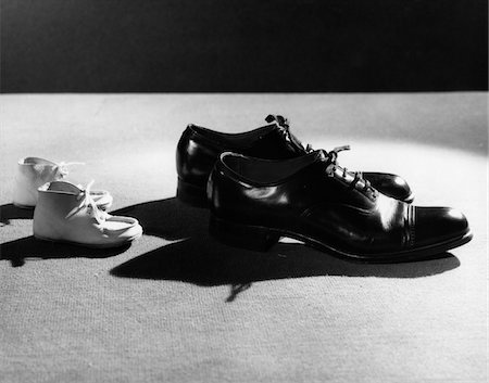 figures in shadows - 1930s BABY BOOTIES FOLLOWING IN FOOTSTEPS OF MAN'S SHOES Stock Photo - Rights-Managed, Code: 846-05648391