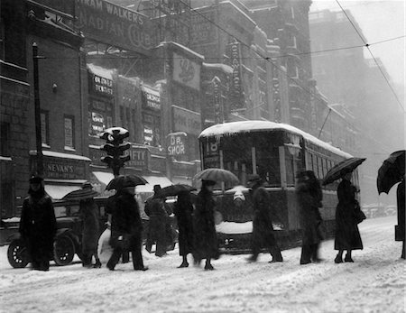 simsearch:846-05648450,k - ANNÉES 1920 - ANNÉES 1930 FOULE TRANSPORTANT DES PARAPLUIES CROISEMENT RUE EN FACE DE LA RUE CHARIOT DE VOITURE PENDANT UNE TEMPÊTE DE NEIGE Photographie de stock - Rights-Managed, Code: 846-05648436