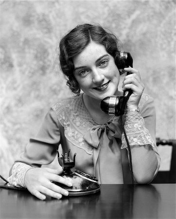 1920s PORTRAIT PRETTY WOMAN SMILING TALKING ON FANCY TELEPHONE WEARING LACE COLLAR CUFFS INDOOR LOOKING AT CAMERA Stock Photo - Rights-Managed, Code: 846-05648457