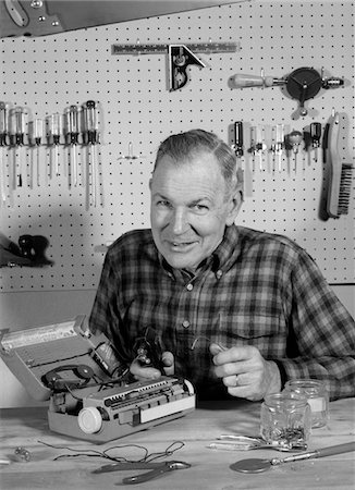 simsearch:846-05648403,k - 1960s MAN REPAIRING PORTABLE RADIO IN HOME WORKSHOP SMILING LOOKING AT CAMERA INDOOR Stock Photo - Rights-Managed, Code: 846-05648489