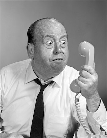 frustration vintage - 1960s - 1970s ANGRY BALDING MAN LOOKING BUG-EYED INTO TELEPHONE RECEIVER Stock Photo - Rights-Managed, Code: 846-05648492