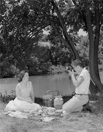 1950s TEENAGE COUPLE PICNIC BOY TAKING PHOTOGRAPH OF GIRL OUTDOORS Foto de stock - Con derechos protegidos, Código: 846-05648507