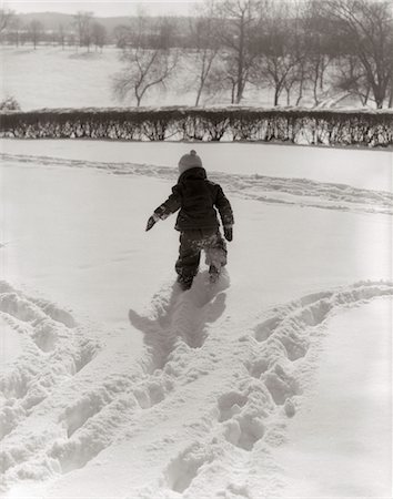 simsearch:846-06112235,k - 1950ER JAHRE ZURÜCK VIEW KIND IN SNOWSUIT SPUREN IM FRISCHEN SCHNEE DRAUßEN MACHEN Stockbilder - Lizenzpflichtiges, Bildnummer: 846-05648519