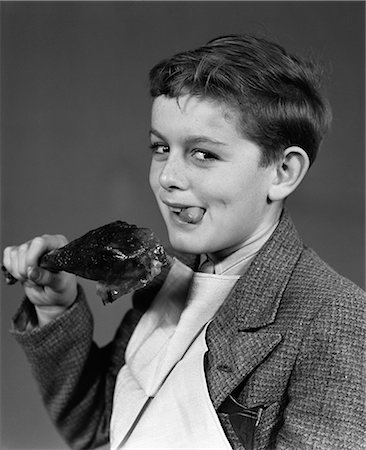 1930s 1940s PORTRAIT OF BOY WITH NAPKIN BIB HOLDING ROAST TURKEY LEG SMILING LOOKING AT CAMERA Stock Photo - Rights-Managed, Code: 846-06111804
