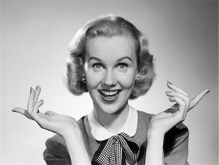 simsearch:846-02796223,k - 1950s SMILING BLONDE PORTRAIT FEMALE PALMS UP INDEX FINGERS EXTENDED Stock Photo - Rights-Managed, Code: 846-06111830