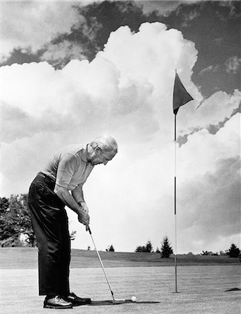 simsearch:846-06111843,k - 1970s MAN PLAYING GOLF PUTTING GOLF BALL ON GREEN TO FLAG AND CUP OUTDOOR Stock Photo - Rights-Managed, Code: 846-06111865